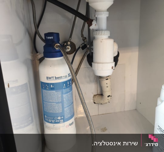 מתחת לכיור עם מסנן מים וצנרת